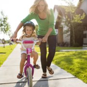 Young girl learning to ride a bike.